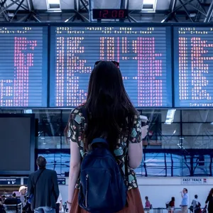 vrouw kijkt naar bord met vertrektijden