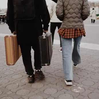 Twee lopende mensen met koffers